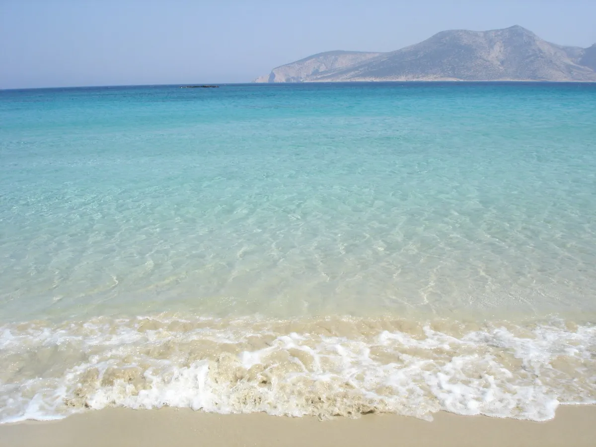 Shallow turquoise water over pale sand at a Koufonisi beach in the Small Cyclades near Naxos, Greece